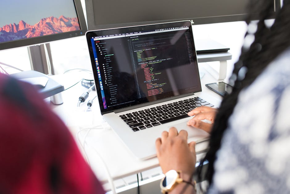 A woman coding on a laptop in a modern office